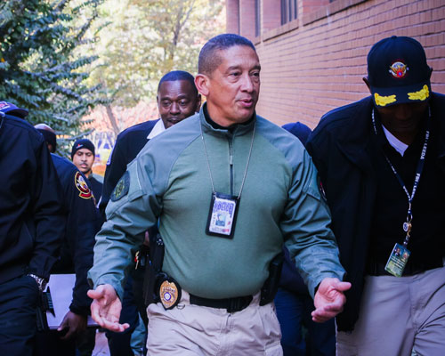 a police member walks with others while talking