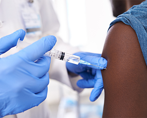 a doctor injects a needle into an arm