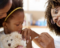 a girl gets a shot while holding a teddy bear