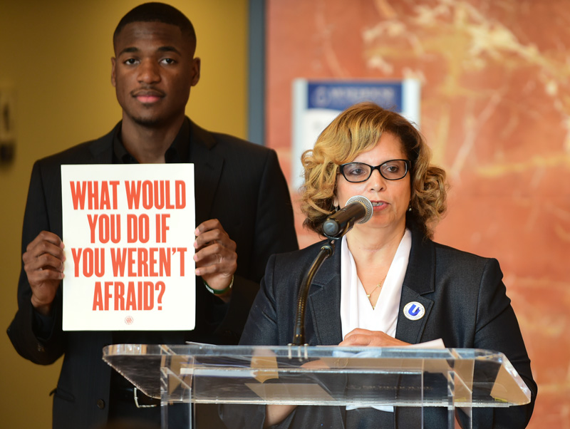 Holding a sign that says What would you do if you weren’t afraid