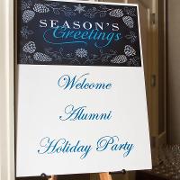 A sign reading"Welcome Alumni Holiday Party"