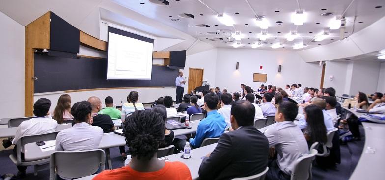 students listening to a teacher in a large room