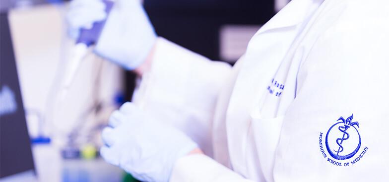 a woman in a lab coat holds a syringe