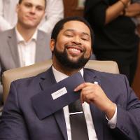 a man holding his match envelope and smiling