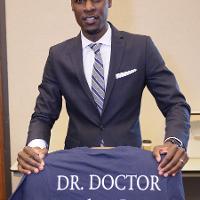 a man holds a shirt reading Dr. Doctor 19