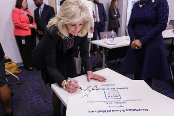 Dr. Jill Biden autographs one of the welcome signs.