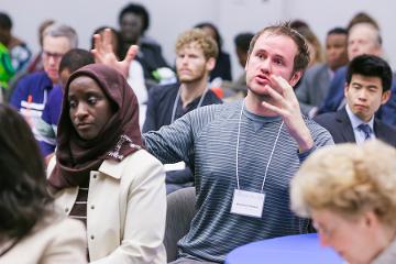 a man is actively engaged in a discussion with a room