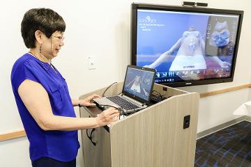 a woman gives a presentation on a screen