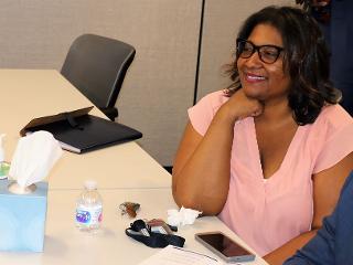 a woman smiling while sitting at a table