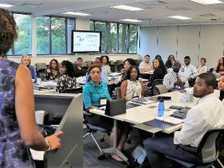 a woman addresses a classroom of students