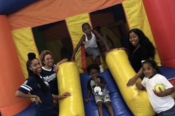 a group of students with younger students on an inflatable slide