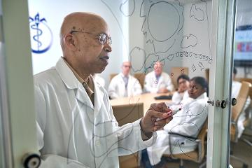 a doctor writes on a glass board