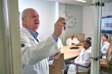 a doctor writes on a glass board