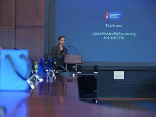 Speaker at podium with slideshow
