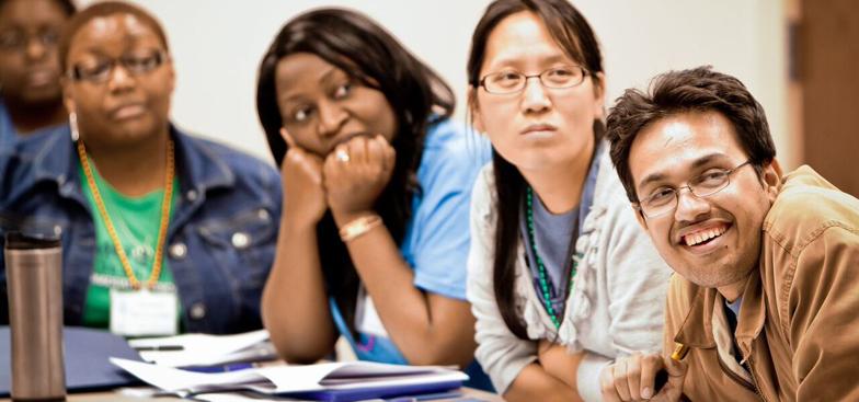 Students smiling while sitting at a table