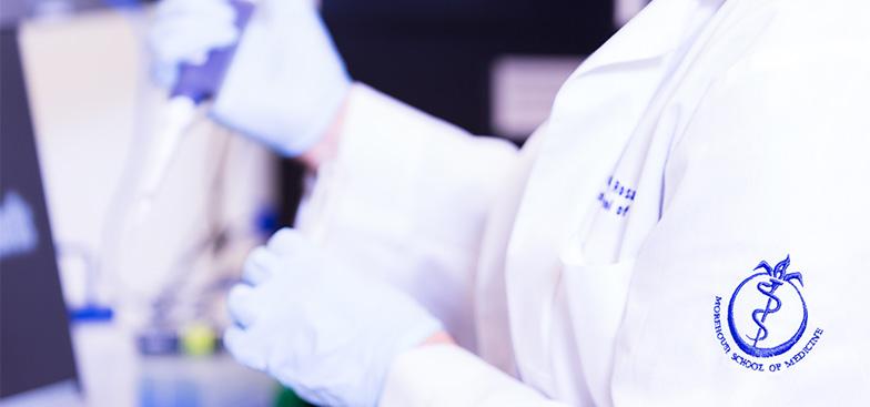 a doctor in a lab coat working with lab equipment