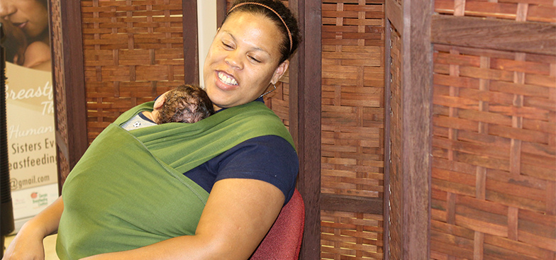 a woman holds her baby in a boba wrap