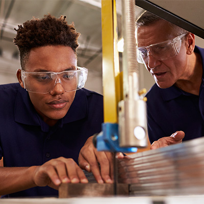 a teach teaches a student to work with a bandsaw