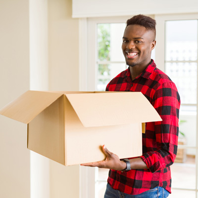 a man carries a large box in a well-lit room